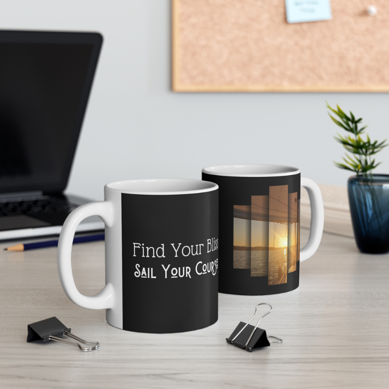 Elegant black coffee mug featuring the motivational text 'Find Your Bliss, Sail Your Course' alongside a serene sunset sailing scene, perfect for adventurers and dreamers.