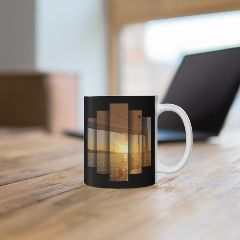 Elegant black coffee mug featuring the motivational text 'Find Your Bliss, Sail Your Course' alongside a serene sunset sailing scene, perfect for adventurers and dreamers.