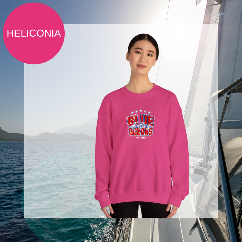 Pink sweatshirt featuring the text 'Blue Sailing Oceans - Est. 1990' in bold red and white with star accents, perfect for nautical enthusiasts.