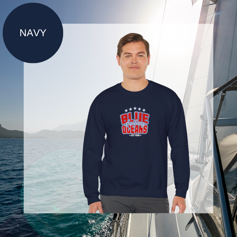 Navy blue sweatshirt featuring the text 'Blue Sailing Oceans - Est. 1990' in bold red and white with star accents, perfect for nautical enthusiasts.