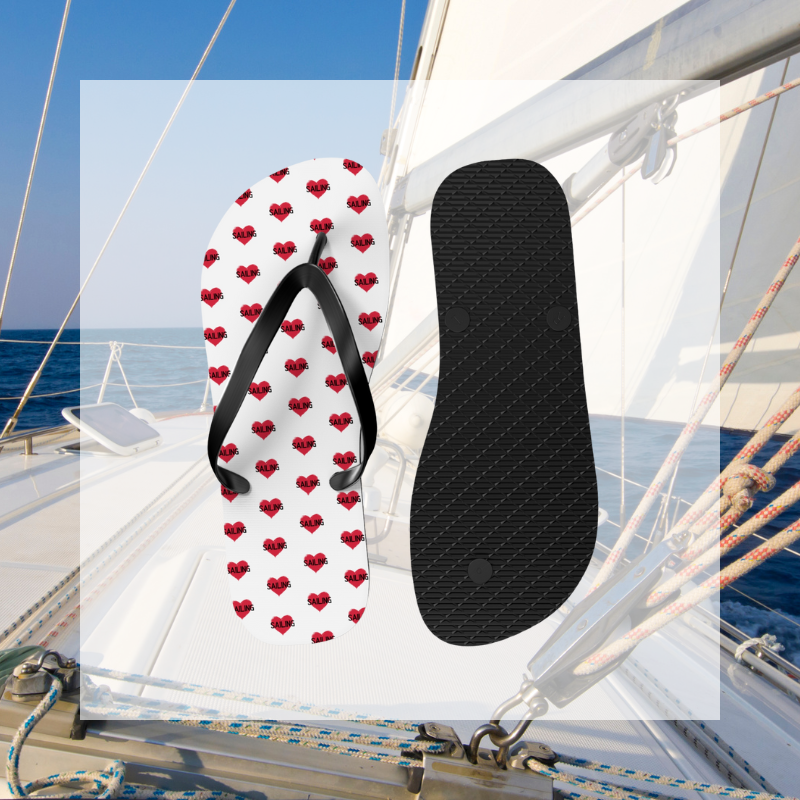White flip-flops adorned with red heart patterns featuring the word 'SAIL,' a perfect accessory for sailing enthusiasts to showcase their passion.