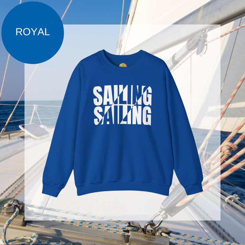 A royal blue men's sweatshirt with a bold white "SAILING" split text design, displayed against a sailing yacht background.