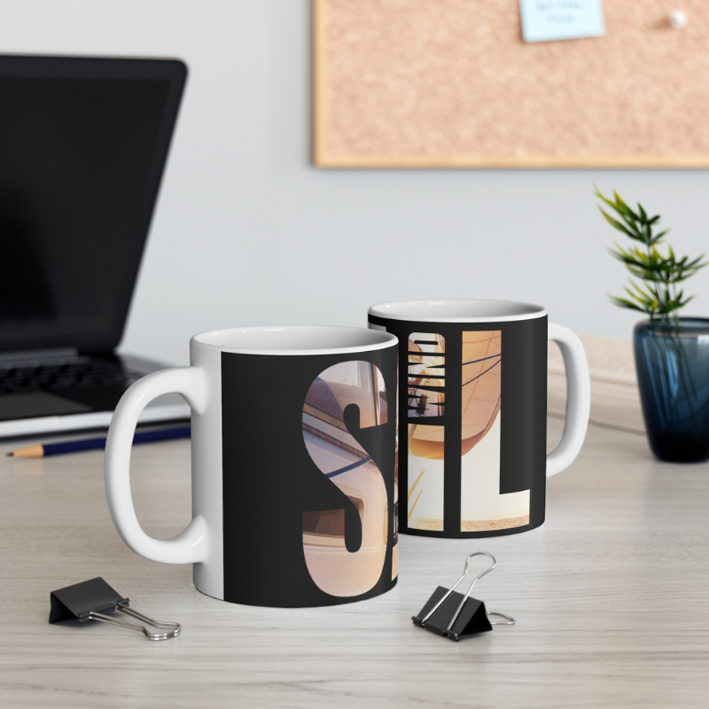 Black coffee mug with bold typography spelling 'SAIL OCEAN WIND,' featuring a vibrant image of a sailboat bathed in warm sunlight, perfect for sailing enthusiasts.