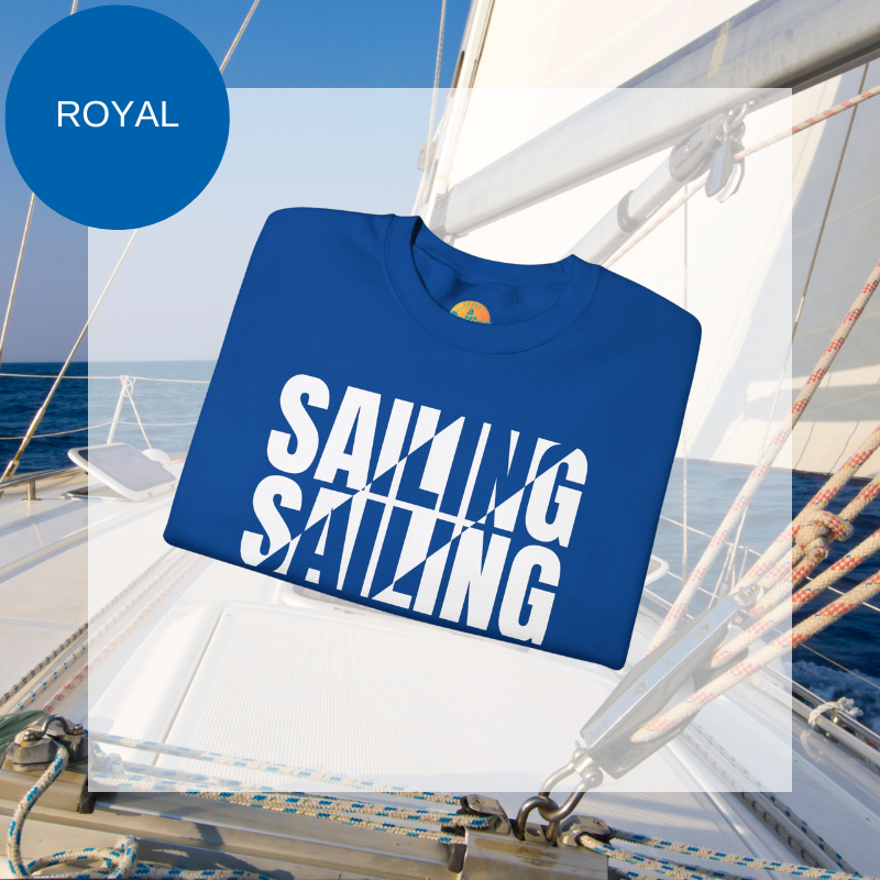 A royal blue men's sweatshirt with a bold white "SAILING" split text design, displayed against a sailing yacht background.