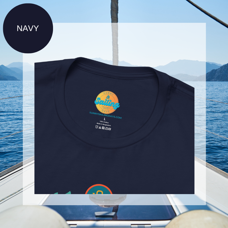 Navy blue unisex t-shirt featuring a vibrant 'Sailyacht Community' design with a sailboat, laurel wreath, and retro sunset, displayed on a yacht deck background.