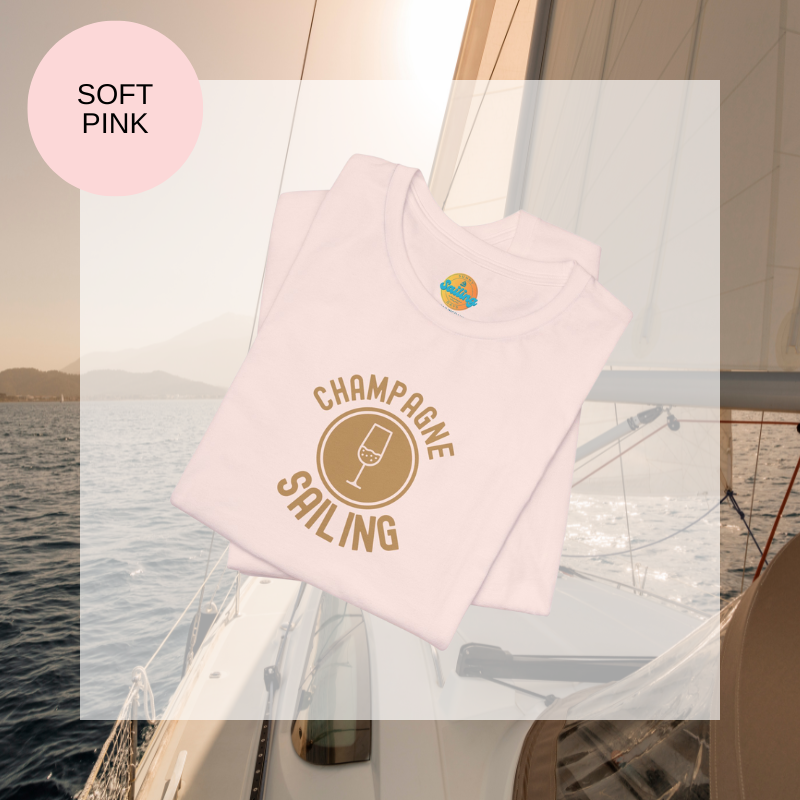Soft pink t-shirt featuring a minimalist design with the text 'Champagne Sailing' in elegant gold lettering and a simple champagne glass icon, perfect for lovers of luxurious sailing vibes.