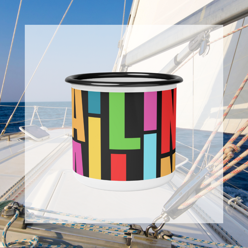 Colorful enamel mug with bold, vibrant 'SAILING' text design in a modern block font, perfect for nautical enthusiasts and lovers of bright, eye-catching patterns, captured against a serene sailing backdrop.