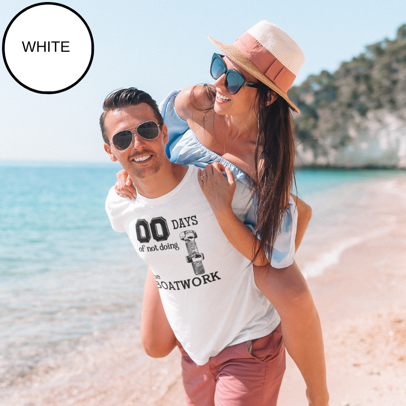 White t-shirt featuring the text '00 Days of Not Doing the Boatwork' with a graphic of a bolt and nut. A humorous and relatable design for boat enthusiasts and DIYers. The background displays a serene view of a yacht deck overlooking calm ocean waters.