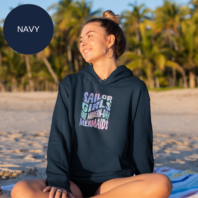 Navy blue hoodie featuring a colorful text design that reads 'Sailor Girls Are Modern-Day Mermaids,' perfect for celebrating nautical style with a whimsical touch.
