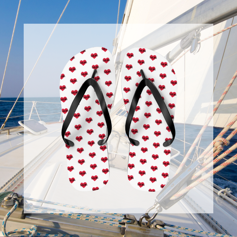 White flip-flops adorned with red heart patterns featuring the word 'SAIL,' a perfect accessory for sailing enthusiasts to showcase their passion.