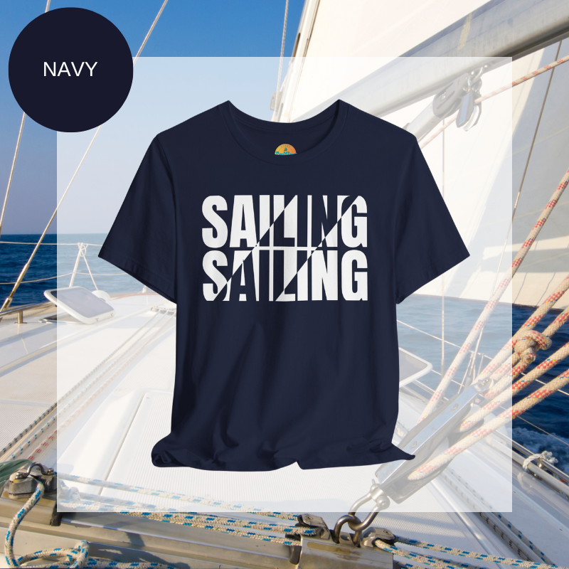 Navy unisex t-shirt with bold white text design reading 'Sailing Sailing,' displayed on a yacht deck with a nautical background.