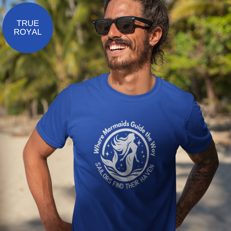 Royal blue unisex t-shirt featuring a whimsical mermaid design with the text 'Where Mermaids Guide the Way, Sailors Find Their Haven,' displayed on a yacht deck background.