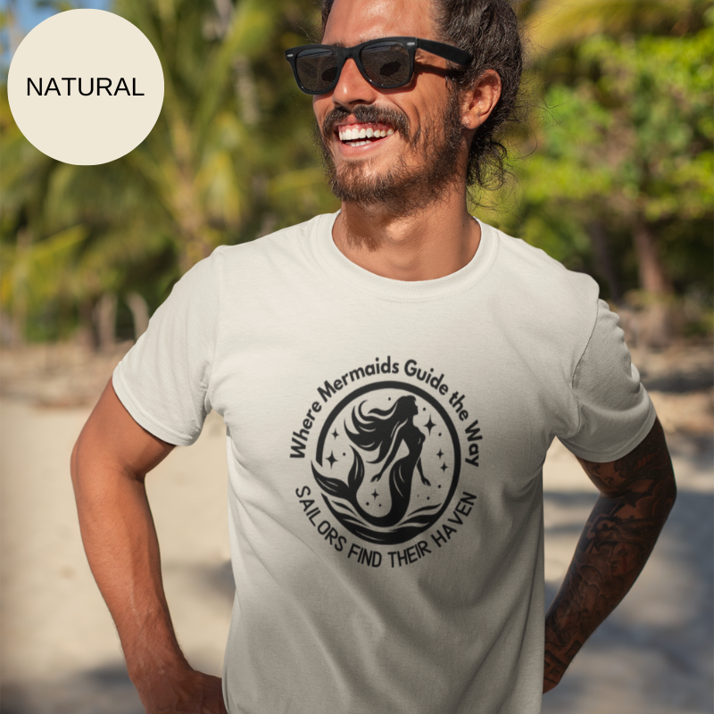 Natural white unisex t-shirt featuring a whimsical mermaid design with the text 'Where Mermaids Guide the Way, Sailors Find Their Haven,' displayed on a yacht deck background.