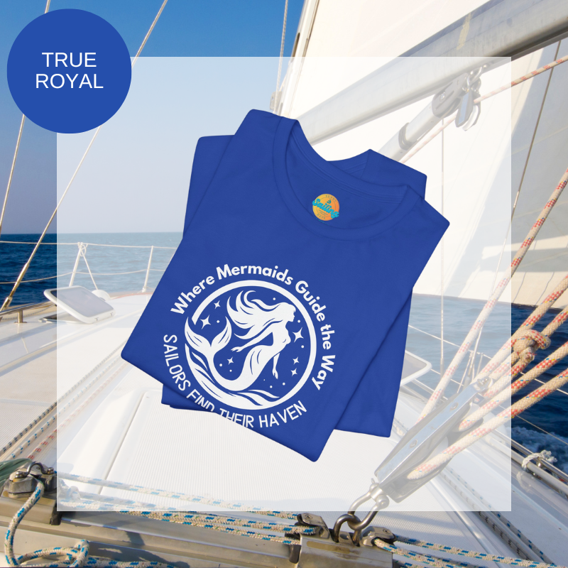 Royal blue unisex t-shirt featuring a whimsical mermaid design with the text 'Where Mermaids Guide the Way, Sailors Find Their Haven,' displayed on a yacht deck background.
