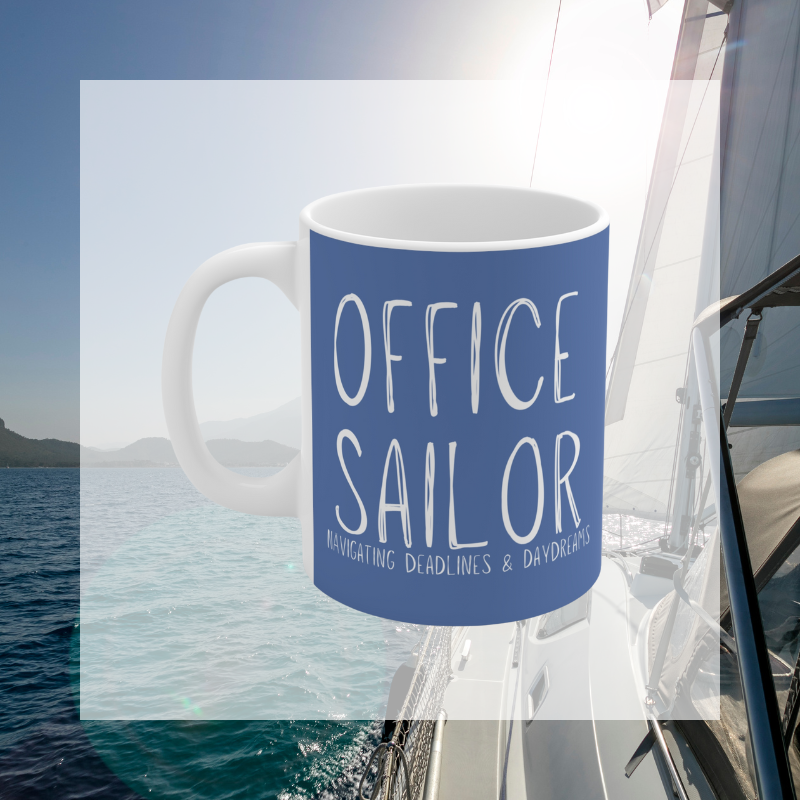 Blue coffee mug with the text 'Office Sailor: Navigating Deadlines & Daydreams,' featuring a playful design of a sailboat inside a coffee cup, perfect for combining work vibes with sailing dreams