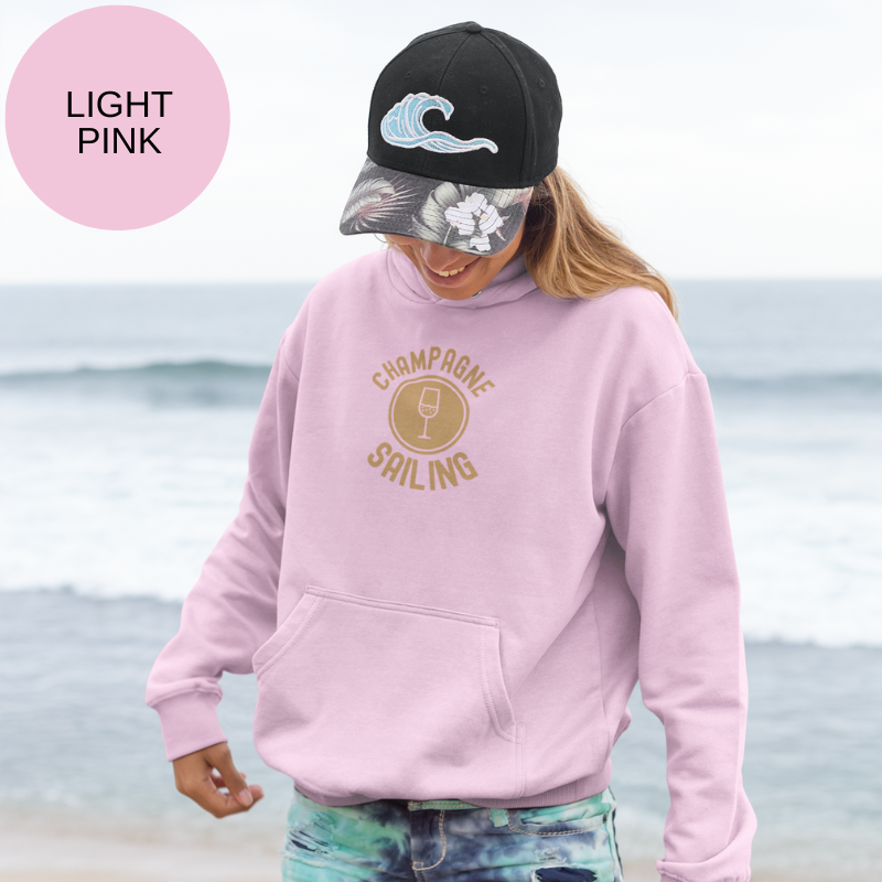Light pink hoodie featuring the elegant 'Champagne Sailing' design with a gold champagne glass icon, perfect for those who love luxurious sailing adventures.