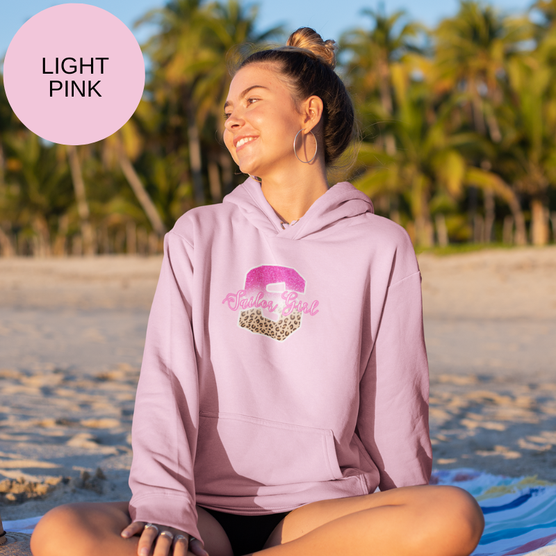 Light pink hoodie featuring a bold 'S' design with pink glitter and leopard print accents, along with the text 'Sailor Girl' in an elegant script font, perfect for nautical enthusiasts with a chic style.