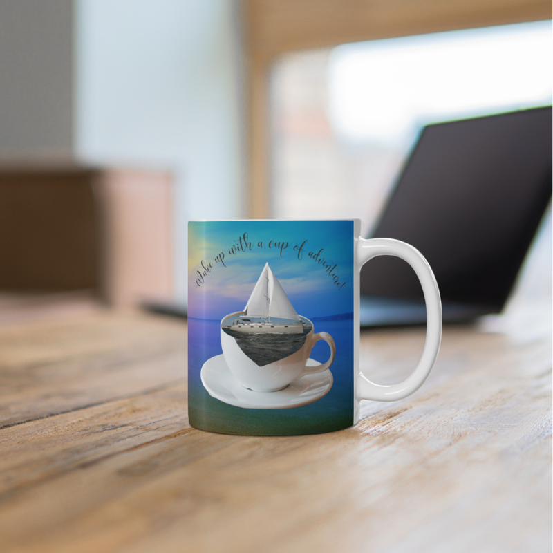 Scenic coffee mug featuring a sailboat floating in a coffee cup with the text 'Wake up with a cup of adventure,' perfect for sailors and dreamers.