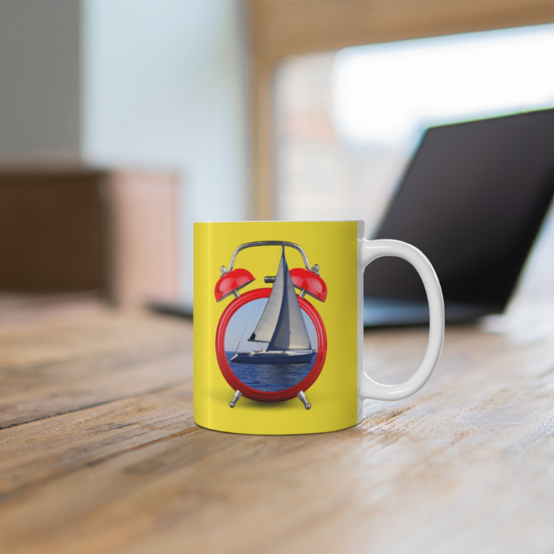 Bright yellow coffee mug featuring the playful text 'It's Sailing O'Clock!' and an alarm clock design with a sailboat inside, perfect for sailing enthusiasts ready to set sail at any time