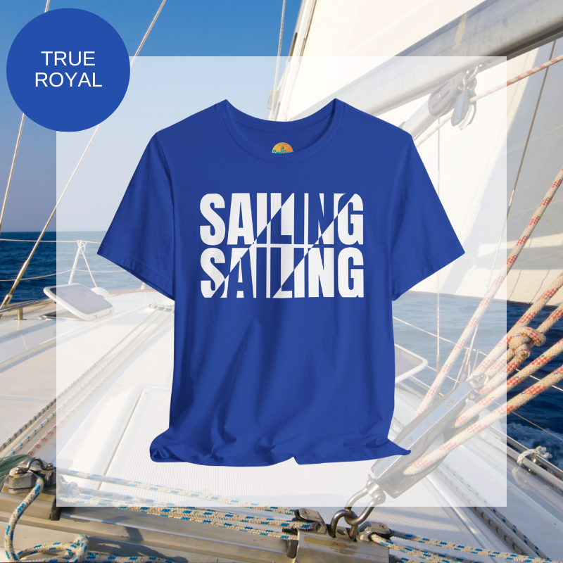 Royal blue unisex t-shirt with bold white text design reading 'Sailing Sailing,' displayed on a yacht deck with a nautical background.
