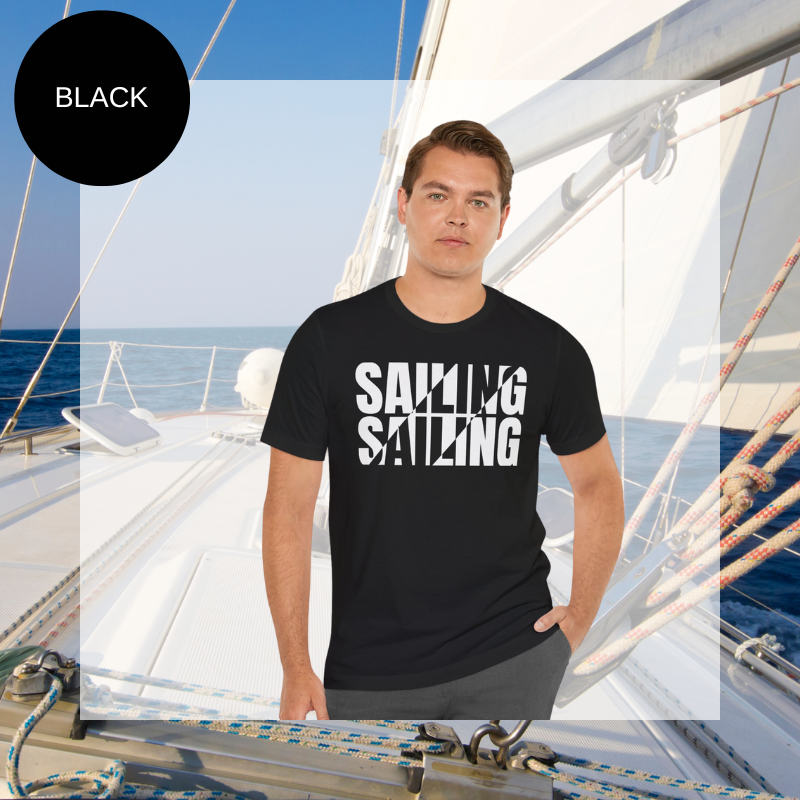 Black unisex t-shirt with bold white text design reading 'Sailing Sailing,' displayed on a yacht deck with a nautical background.