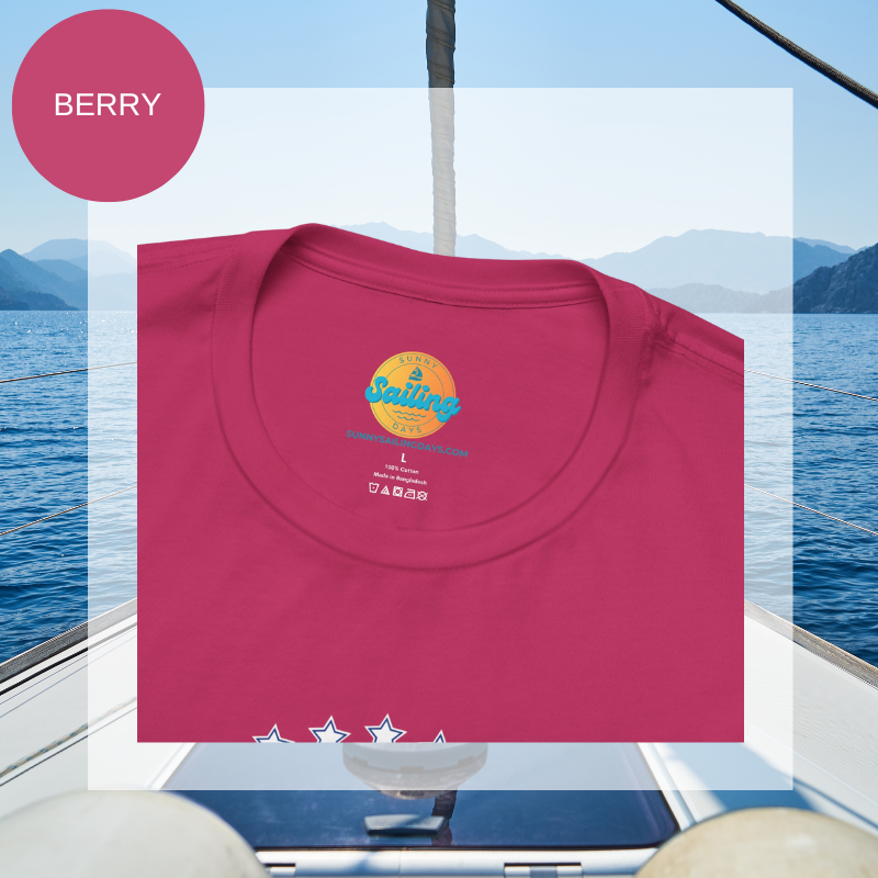 Pink t-shirt featuring red and white text 'Blue Sailing Oceans' with star details. A nautical-themed design perfect for adding a touch of ocean-inspired style. Background shows an open sea view.