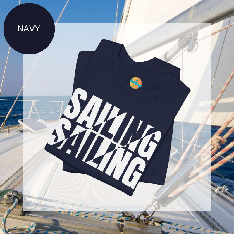 Navy unisex t-shirt with bold white text design reading 'Sailing Sailing,' displayed on a yacht deck with a nautical background.