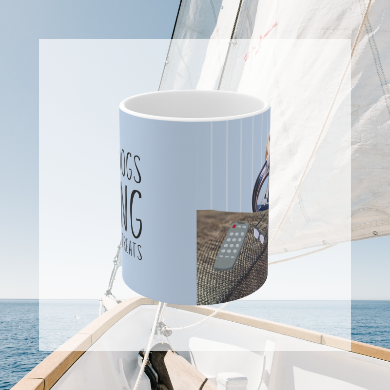 Light blue coffee mug featuring the text 'Salty Dogs Sailing on a Sea of Treats' with a playful illustration of a dog holding a food bowl with a sailboat in it, perfect for dog-loving sailors.