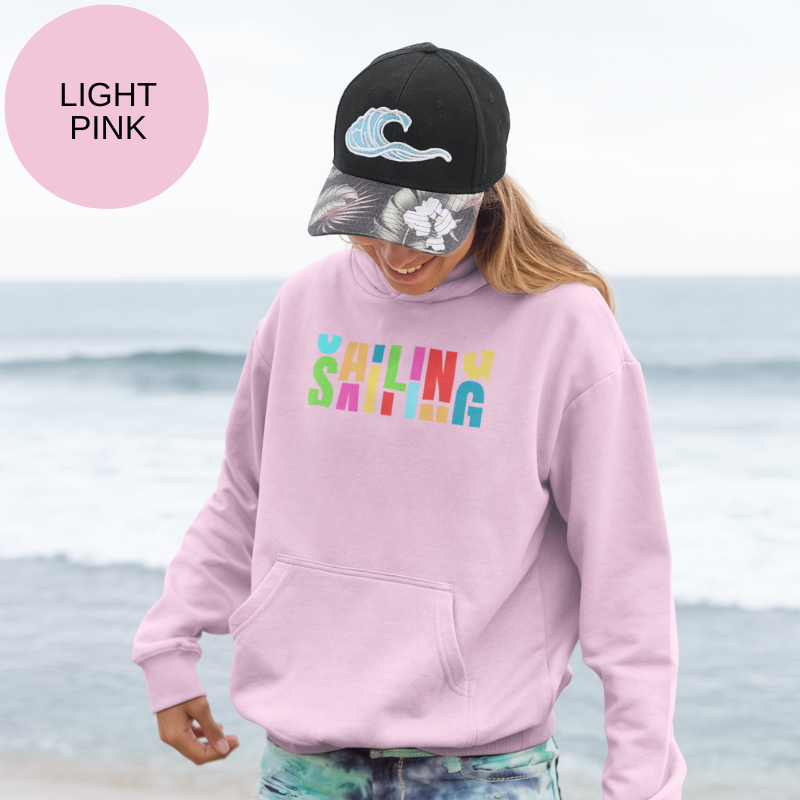 Light pink hoodie featuring a bold and colorful 'Sailing' typographic design, perfect for embracing vibrant nautical adventures.