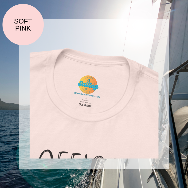 Pink women's t-shirt with the text 'Office Sailor: Navigating Deadlines & Daydreams' and colorful paperclip illustrations, displayed on a sailing-themed background.