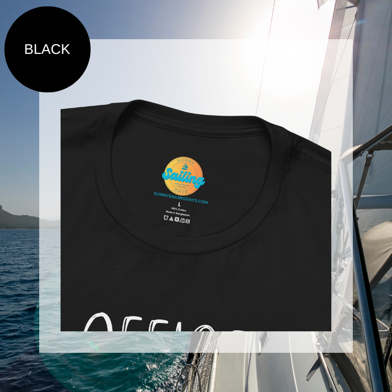 Black women's t-shirt with the text 'Office Sailor: Navigating Deadlines & Daydreams' and colorful paperclip illustrations, displayed on a sailing-themed background.